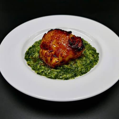 miso glazed chilean sea bass dish on white plate with black background