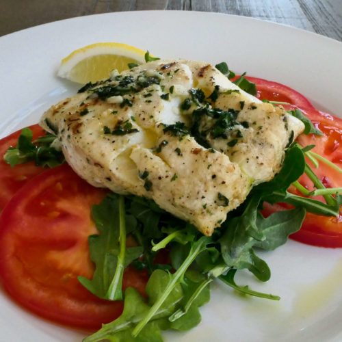 grilled cod with olive oil and parsley on a bed of arugula and tomatoes