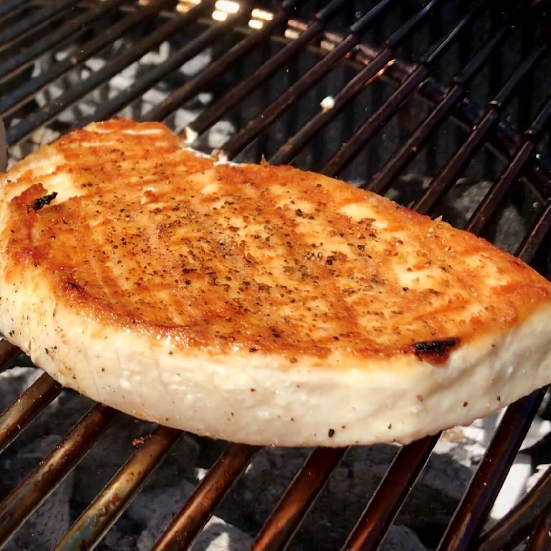 golden brown grilled swordfish steak on the grill with grill marks