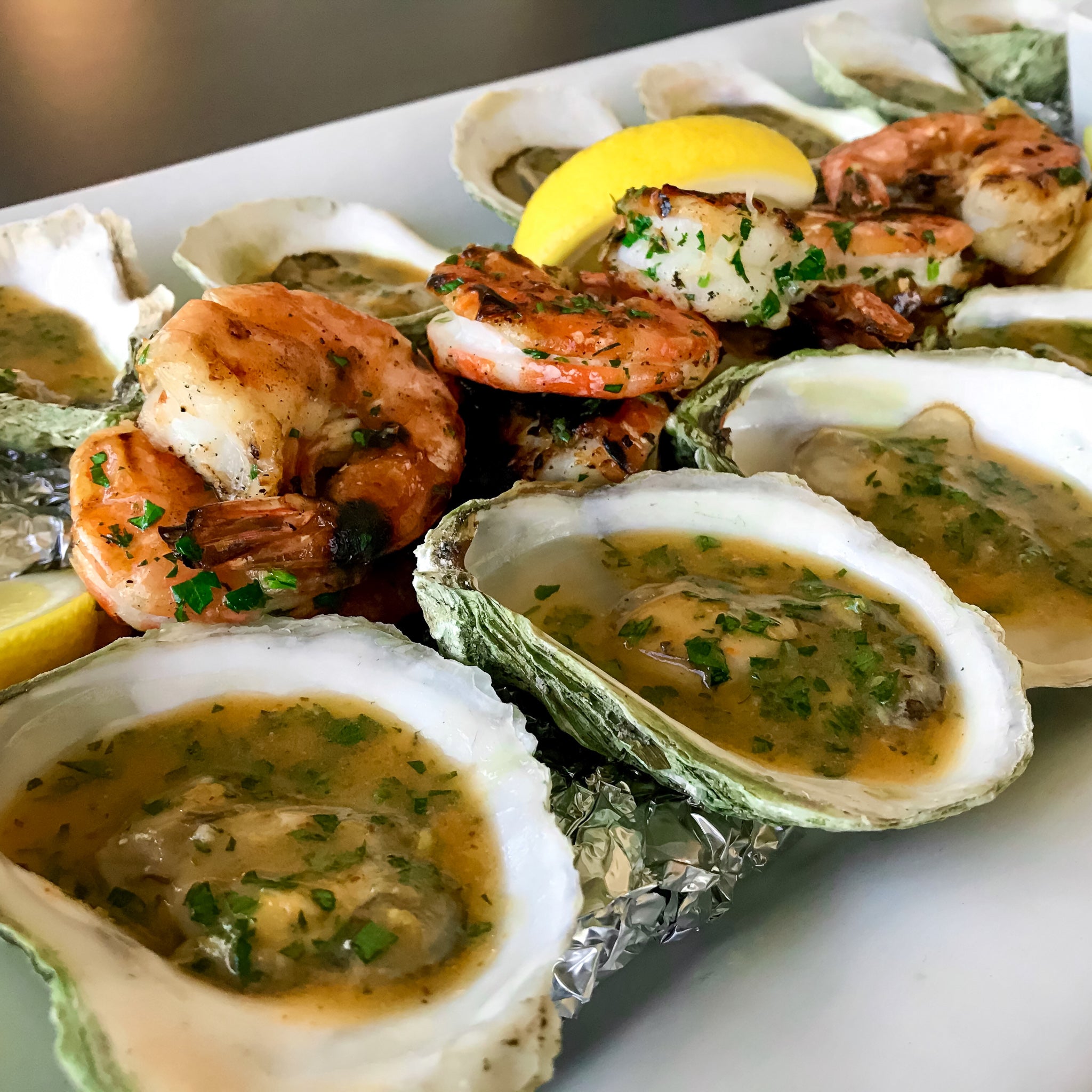 grilled oysters with spicy citrus butter and shrimp on a platter