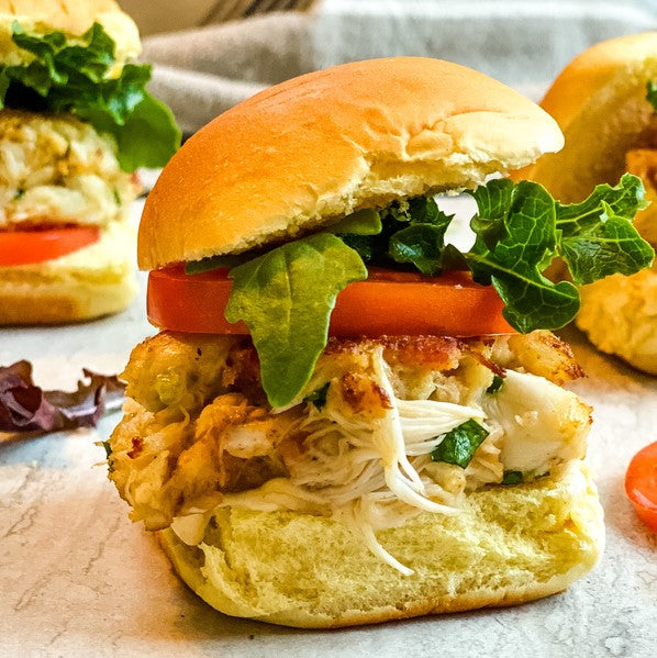 mini crab cake blt sandwiches with lettuce, tomato, on a mini  bun on brown table