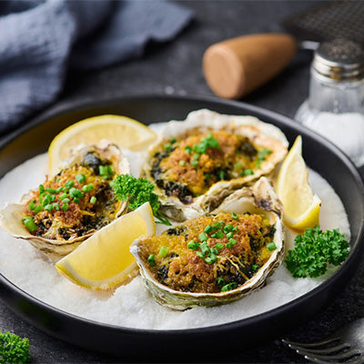 Oysters Rockefeller with lemon and a glass of white wine.