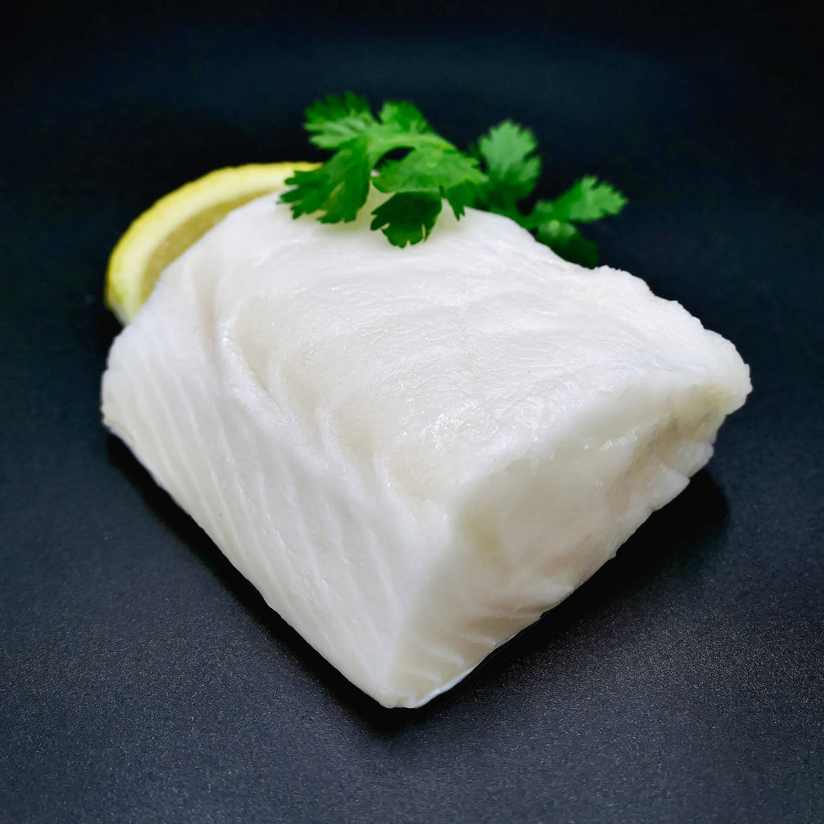 Chilean sea bass portion with parsley and lemon