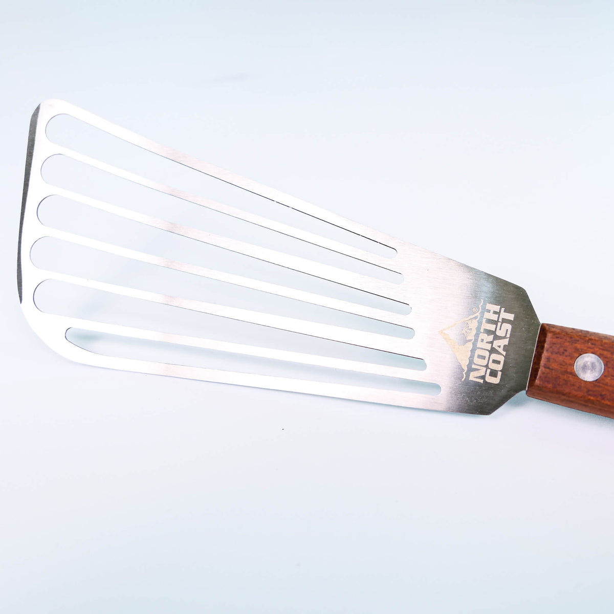 close up of slotted fish spatula on a white background