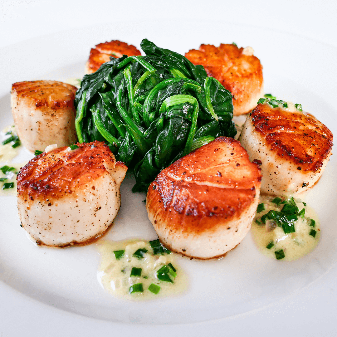 10-20 jumbo sea scallops on a black slate slab with lemon, parsley, and salt crystals