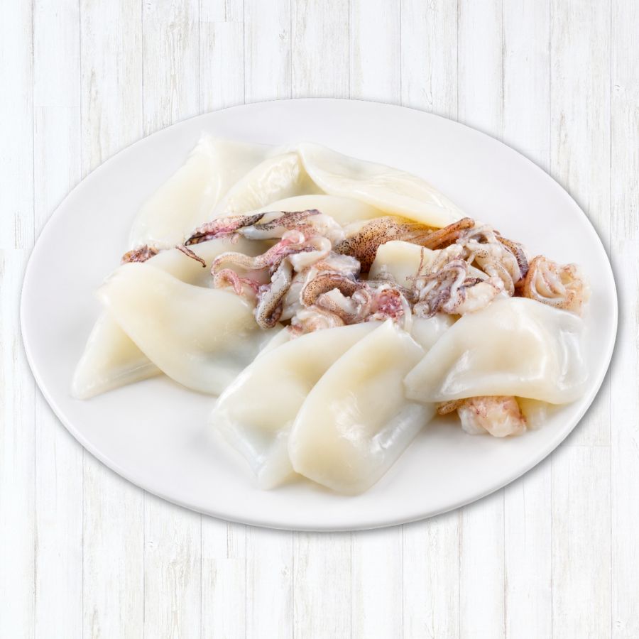 A white plate containing sliced squid or cuttlefish pieces with some tentacles, photographed from above on a light whitewashed wood background.