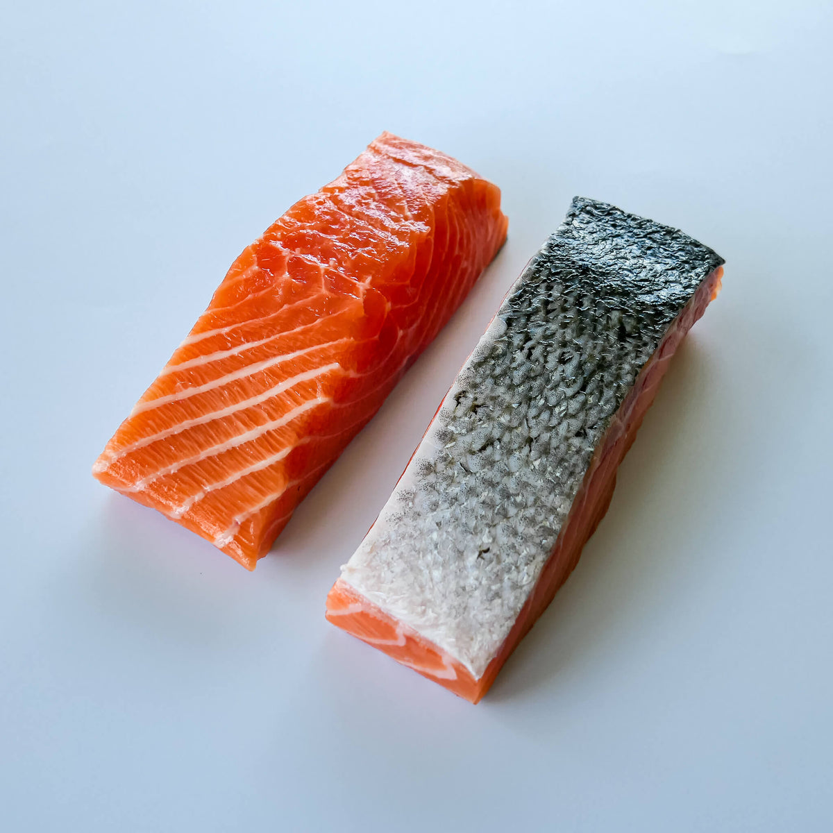 skin on Norwegian Salmon portions on a white background