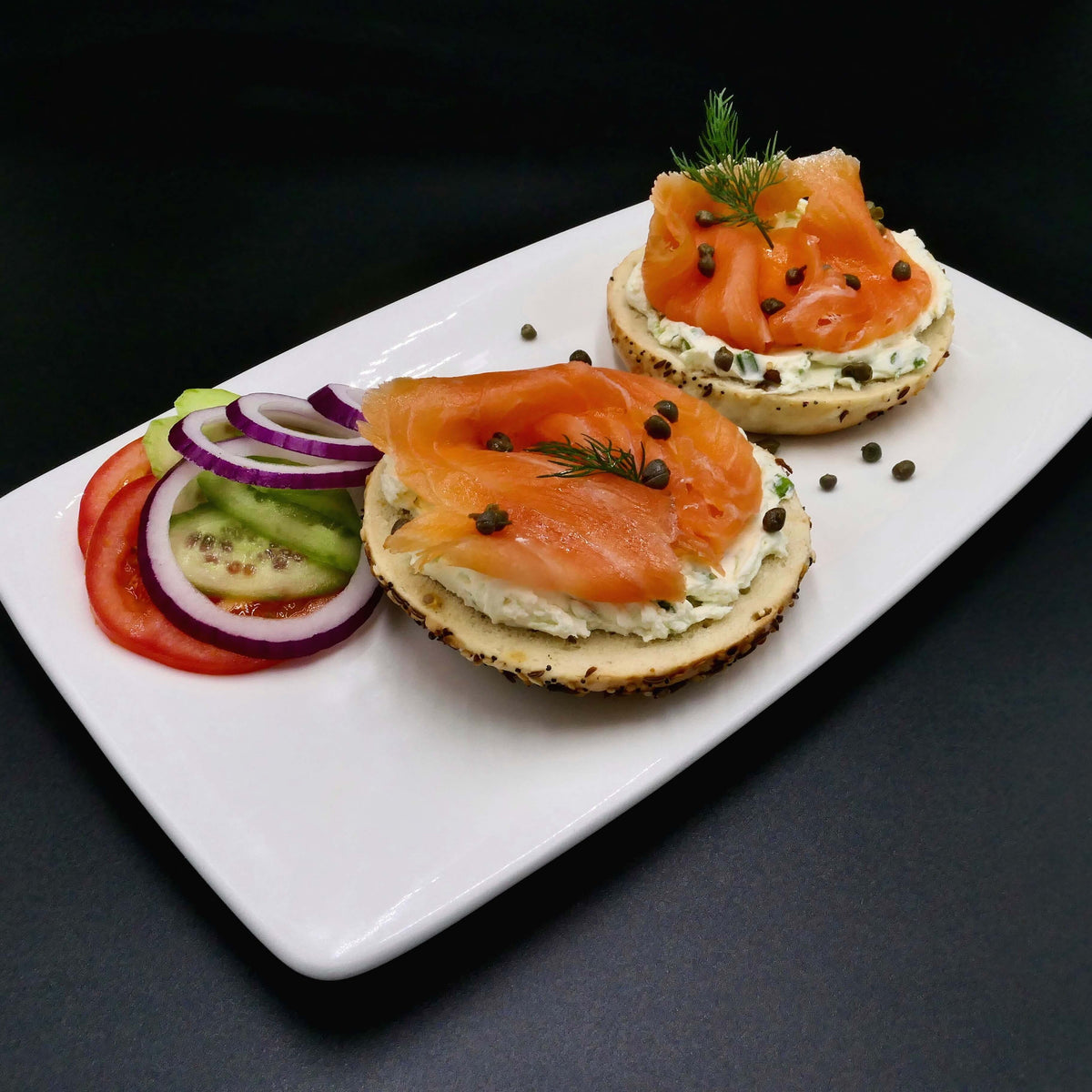 smoked salmon and lox bagel on a white plate