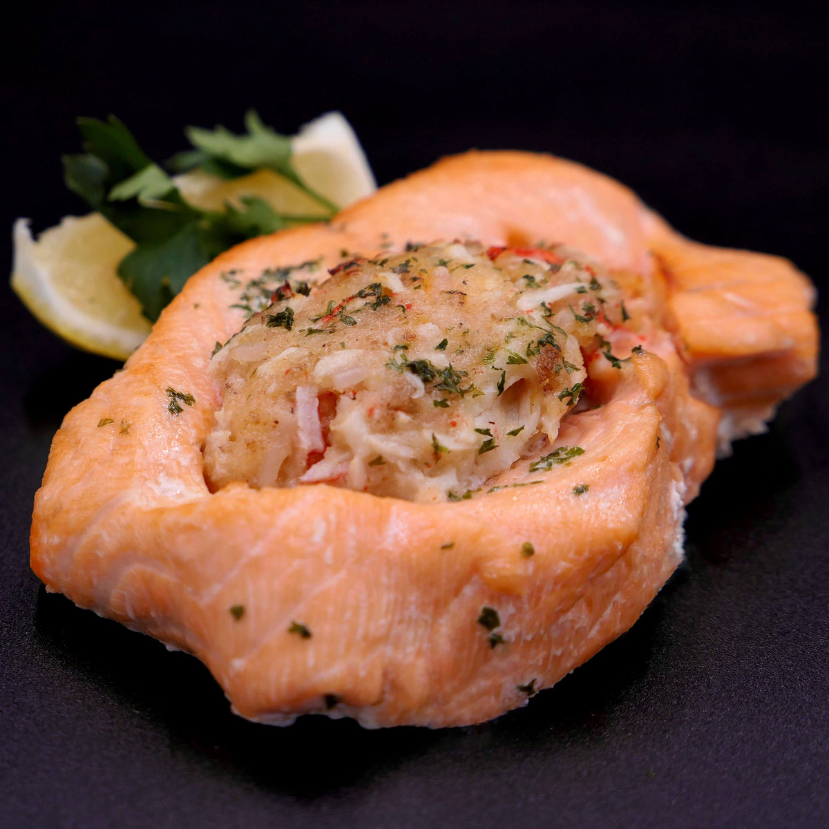 baked stuffed salmon on a black background