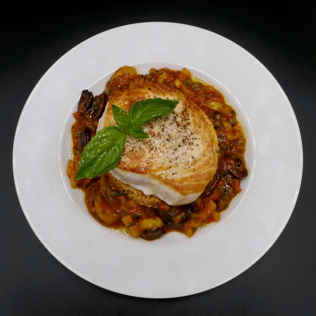 pan seared swordfish steak served on a white plate
